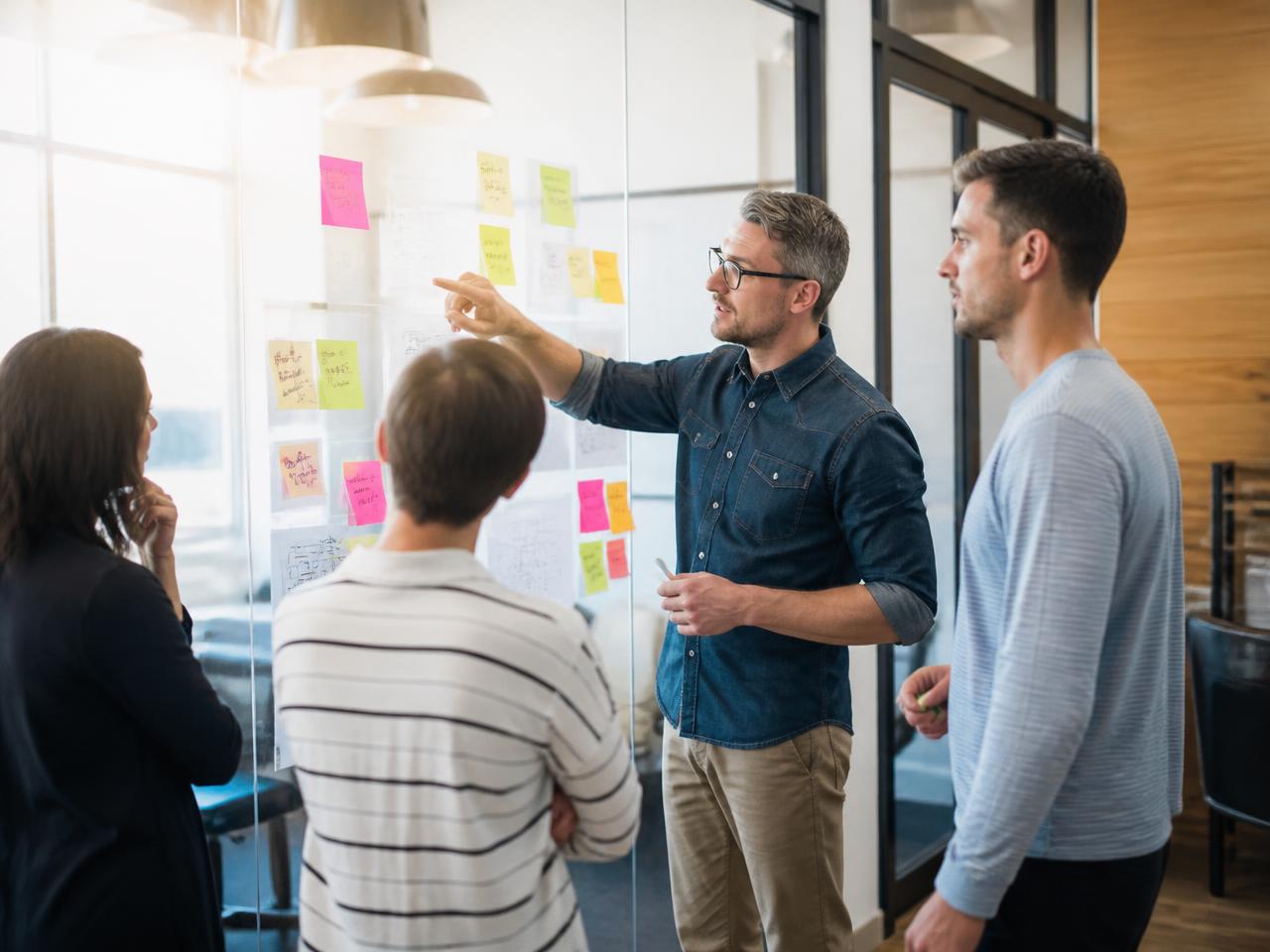 Inocode team running a product discovery workshop with sticky notes on a glass whiteboard